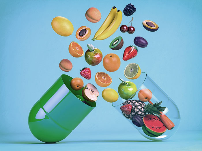 Obst und Gemüse als Inhalt einer Kapsel – symbolische Darstellung von Nahrungsergänzungsmitteln auf natürlicher Basis